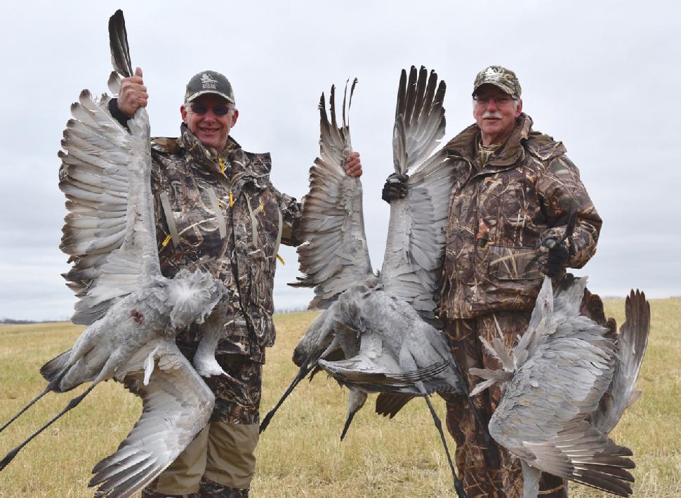 Credit: Ken Bailey. The author (right) after a successful sandhill crane hunt.