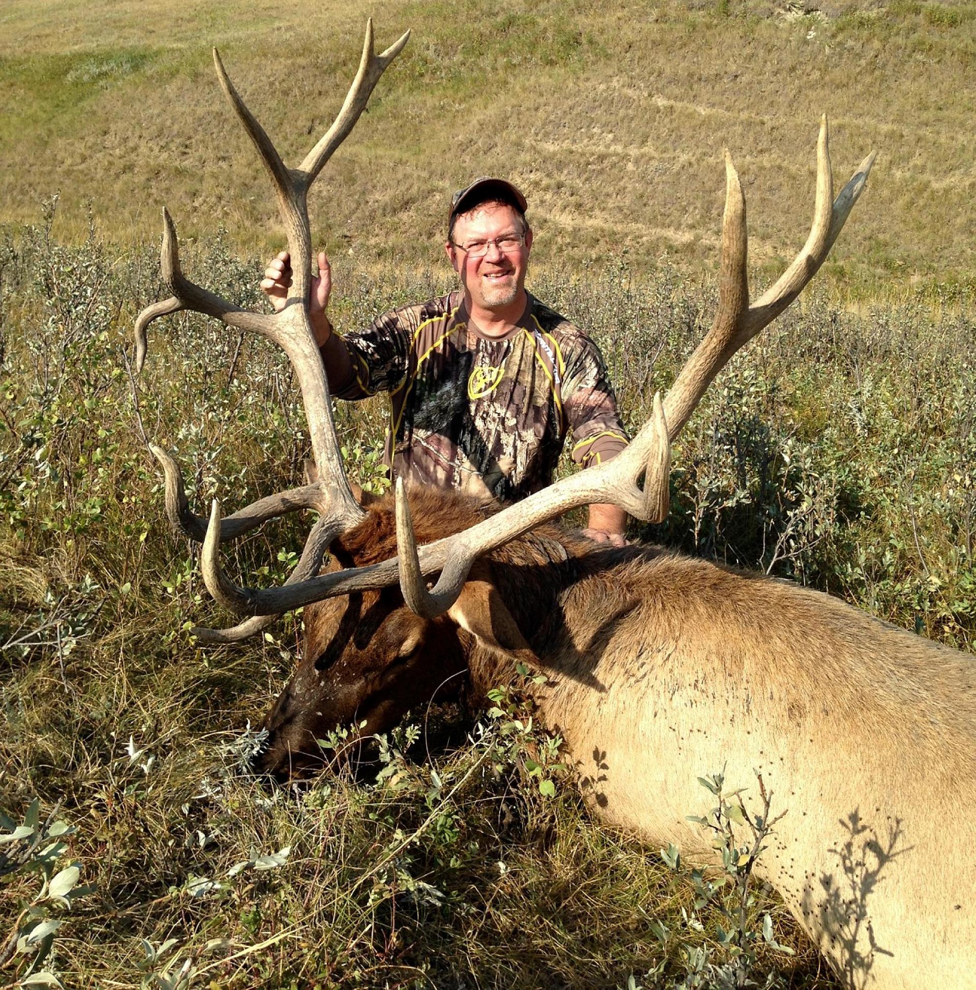 The author and a massive prairie bull elk. Credit: Brad Fenson.