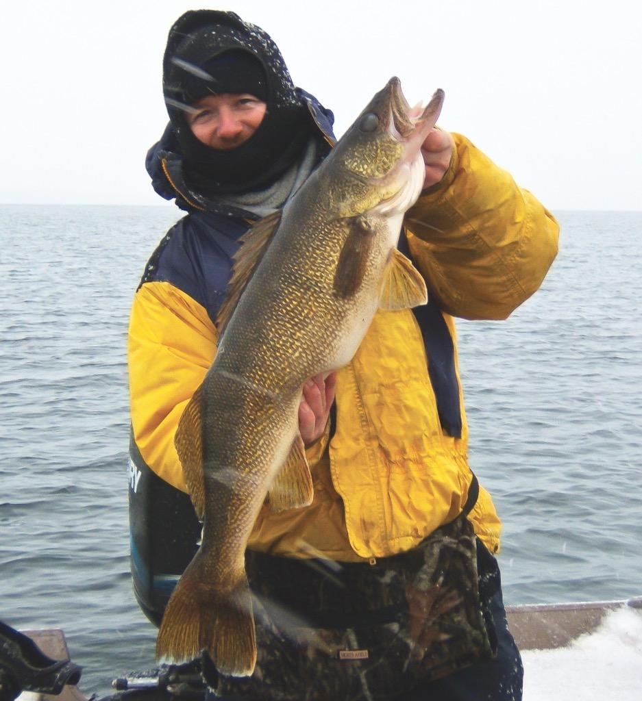 Credit: Pete Bowman. Bowman and a Quinte walleye (note the blowing snow).