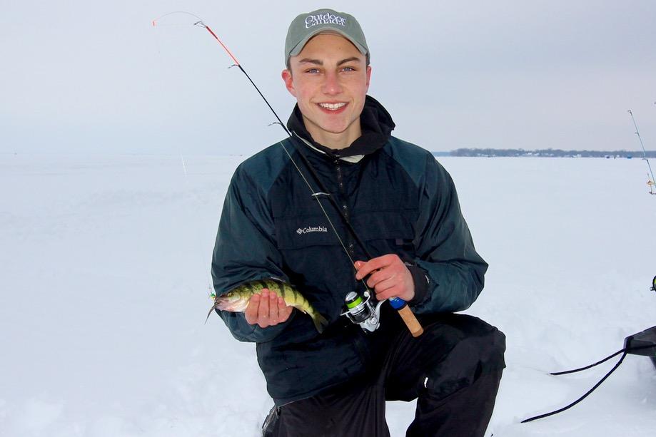 Ice angler Ezra Laskar shows off his trusty ice rod, and a yellow perch from Ontario's Lake Simcoe. Credit: Scott Gardner.