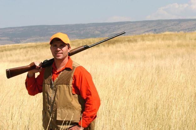 Hunter with a yellow hat and a rifle