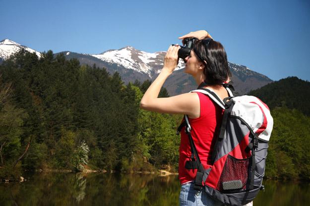 Photographer taking a photo of the mountains and trees