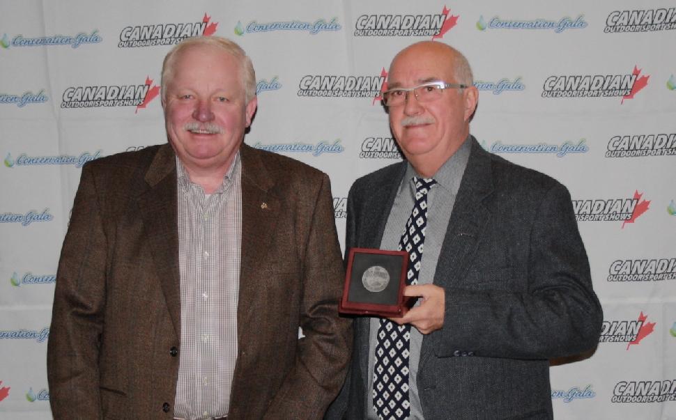 Phil Morlock, director of Environmental Affairs for Shimano (left), presents MP Garry Breitkreuz (right) with the 2015 Rick Amsbury Award of Excellence. Credit: Scott Gardner.