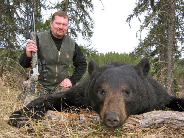 A hunter with his black bear kill