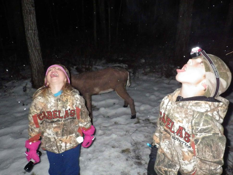 Kids catching snowflakes at night