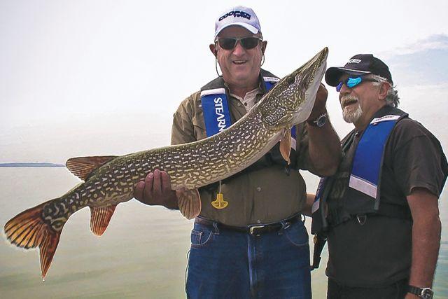 Credit: Pete Bowman. Cooper Tire’s Roy Armes (left) and Angelo Viola with a giant Winefred Lake pike.