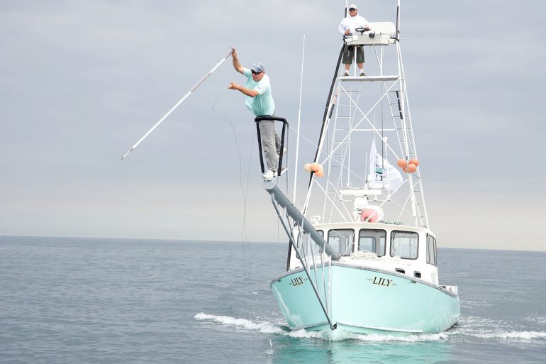 GLOUCESTER, MASS.- Captain Bill "Hollywood" Muniz takes aim with his harpoon aboard the Lily while First Mate Jimmy Lund looks on. (Photo Credit: Pilgrim Films & Television/Joe Scott)