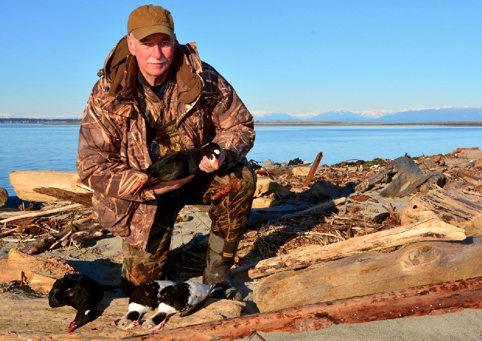 Credit: Ken Bailey The author holds a surf scoter; at his feet lie a white-winged scoter and two longtails